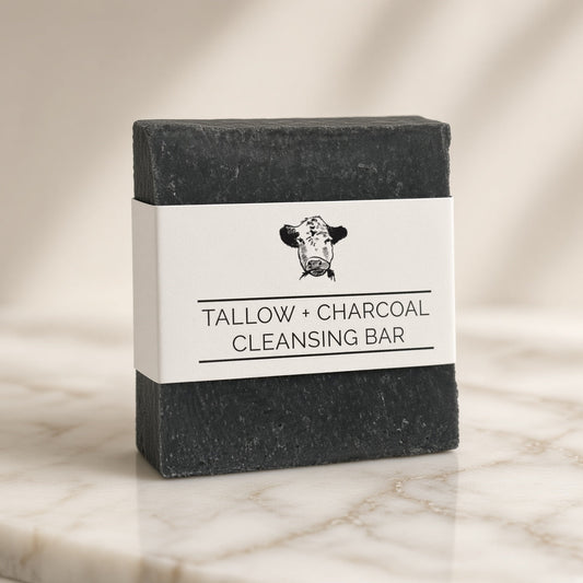 Charcoal tallow soap bar made with grass-fed beef tallow on marble, angled view