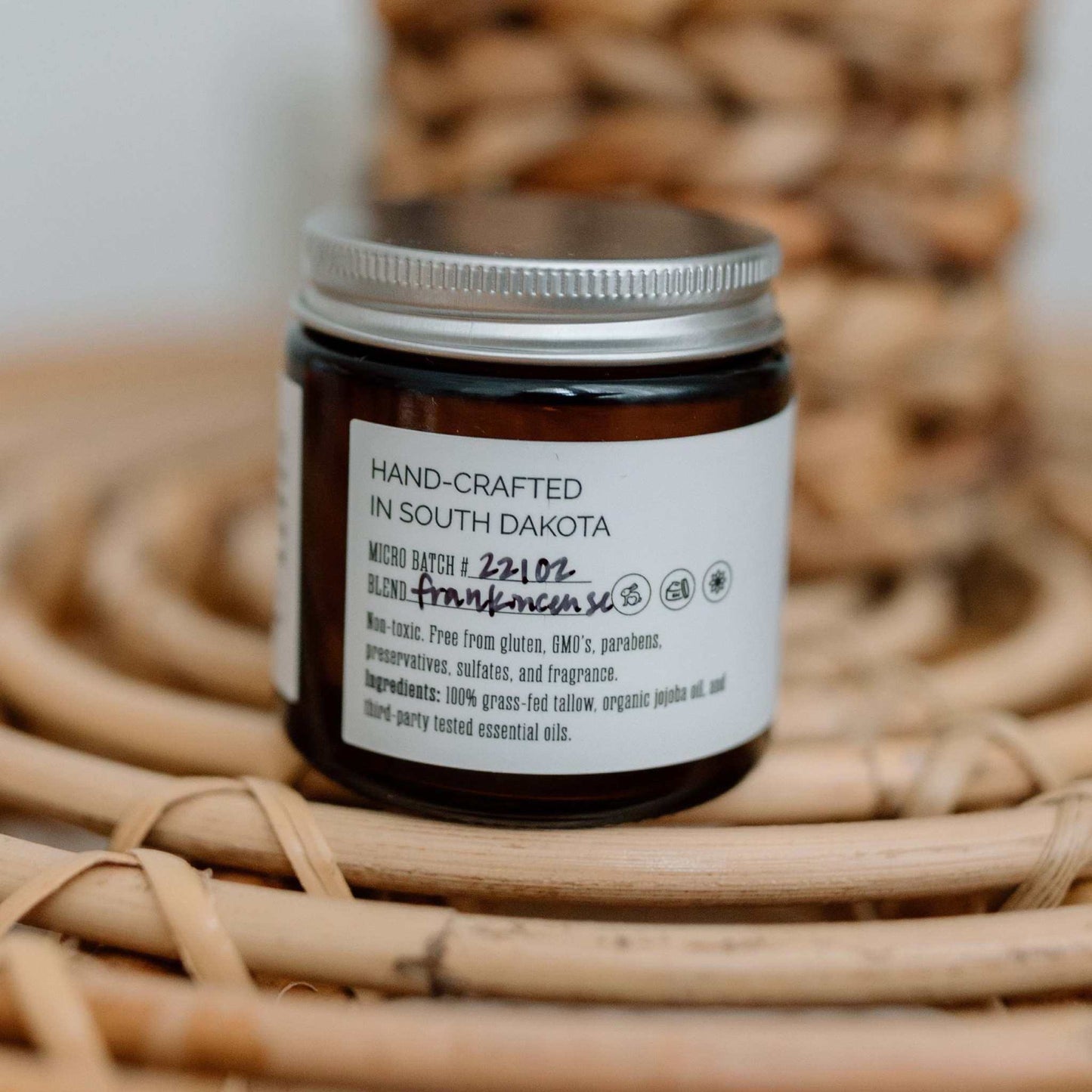 Whipped tallow balm jar with frankincense label on wicker background natural skincare moisturizer